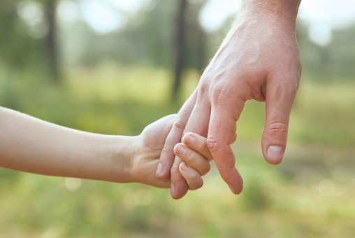 Vater hält die Hand seines Kindes